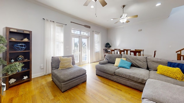 living room with ornamental molding, light wood-type flooring, and ceiling fan