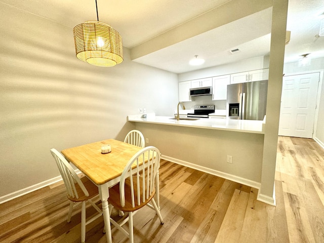 dining space featuring sink and light wood-type flooring