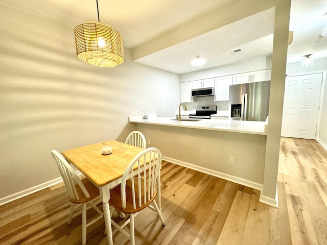 200 Sandestin Ln Unit 1307, Miramar Beach, FL 32550 - kitchen featuring appliances with stainless steel finishes, a sink, light wood-type flooring, and baseboards