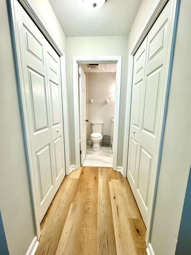 200 Sandestin Ln Unit 1307, Miramar Beach, FL 32550 - hallway with light wood-style flooring, a textured ceiling, and baseboards