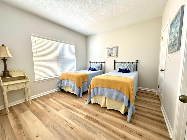 200 Sandestin Ln Unit 1307, Miramar Beach, FL 32550 - bedroom featuring light wood-style floors, a textured ceiling, and baseboards