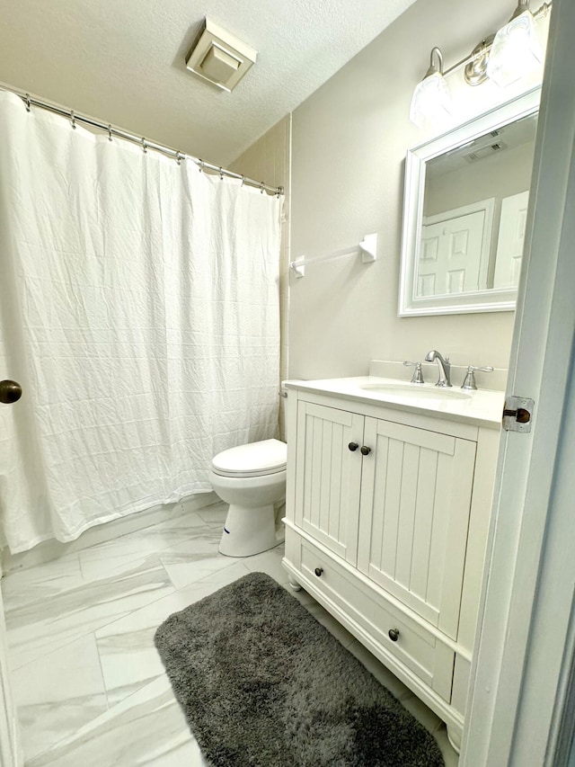 bathroom with vanity, a shower with curtain, a textured ceiling, and toilet