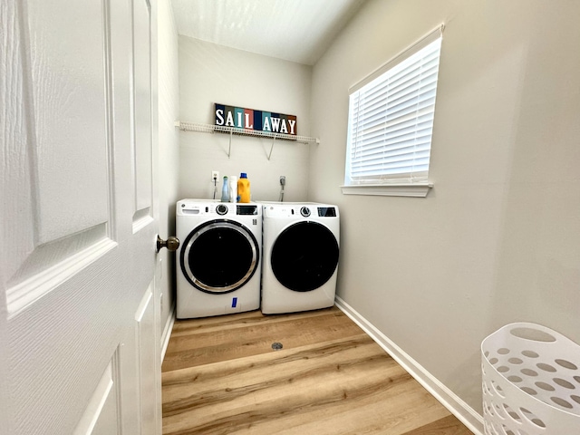 laundry room with washer and dryer and hardwood / wood-style flooring