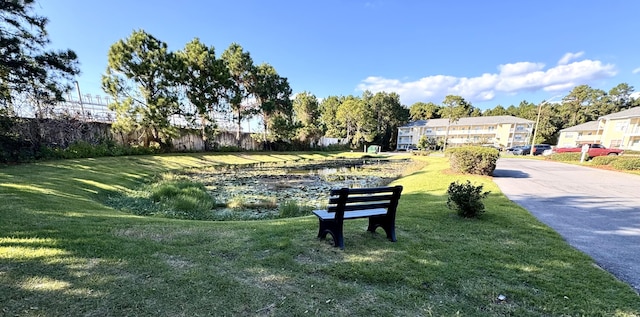 view of home's community with a water view and a yard