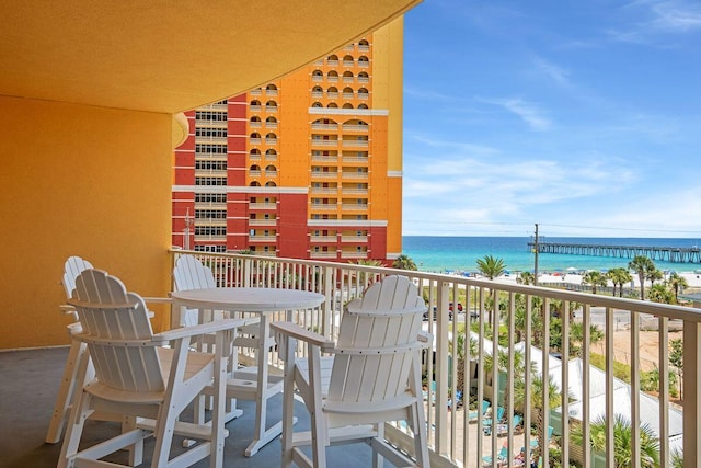 balcony with a water view and a beach view