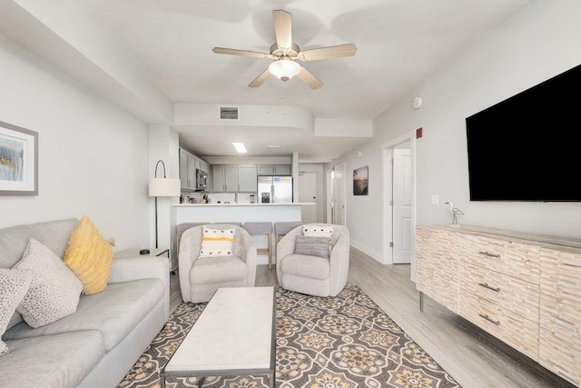 living room featuring light hardwood / wood-style flooring and ceiling fan