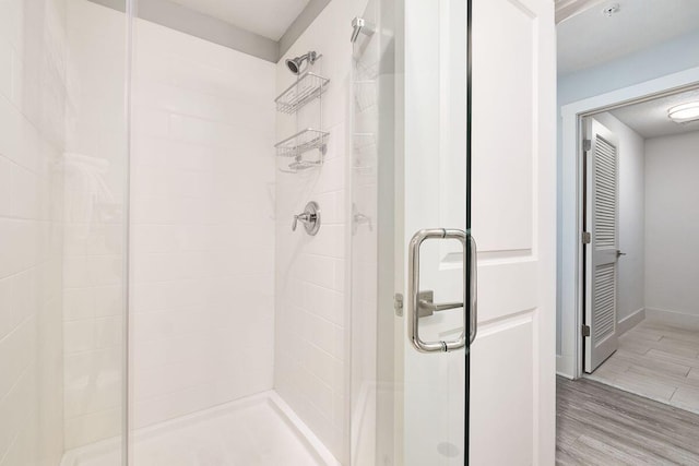 15928 Front Beach Rd Unit 3-409, Panama City Beach, FL 32413 - full bathroom featuring baseboards, wood finished floors, and a shower stall