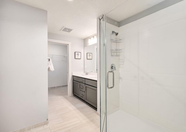 bathroom with vanity and a shower with shower door