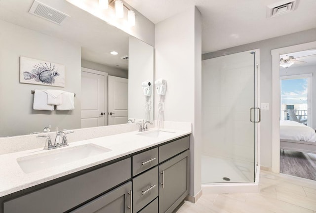 bathroom with vanity, a shower with shower door, and ceiling fan