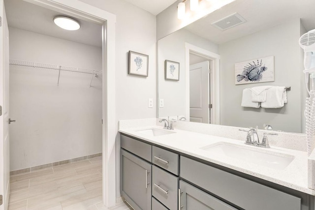 15928 Front Beach Rd Unit 3-409, Panama City Beach, FL 32413 - bathroom with double vanity, visible vents, a sink, and a spacious closet
