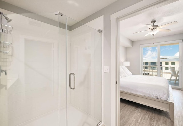 bathroom featuring a shower with door, ceiling fan, and wood-type flooring