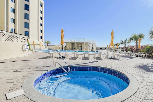 view of pool featuring a patio and a community hot tub