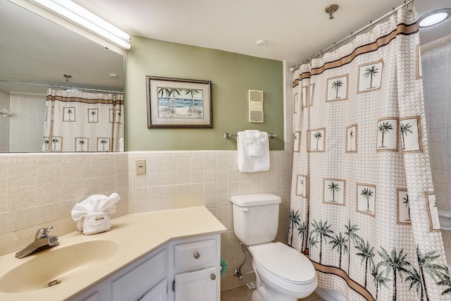 bathroom featuring toilet, tile patterned floors, tile walls, walk in shower, and vanity