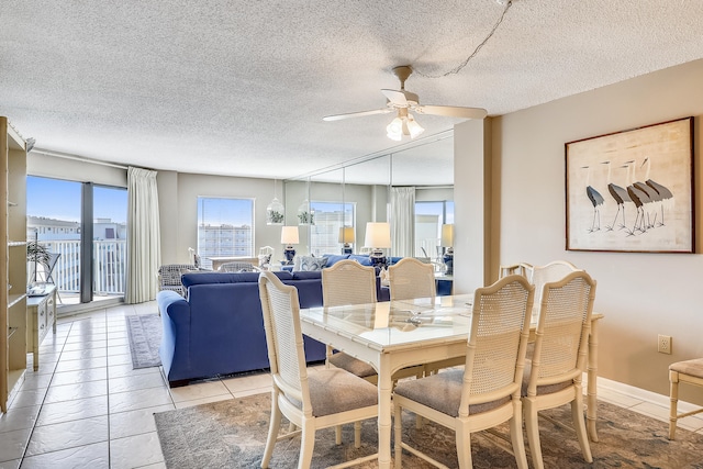 dining area with ceiling fan, a textured ceiling, and light tile patterned floors