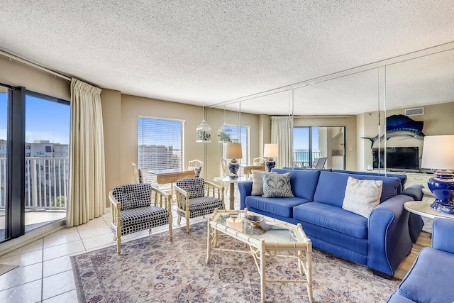 living room with a textured ceiling and light tile patterned floors