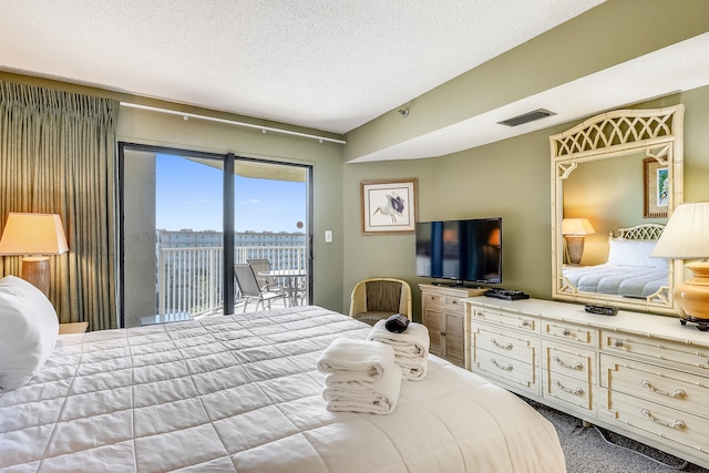 bedroom featuring a textured ceiling, access to outside, and carpet floors