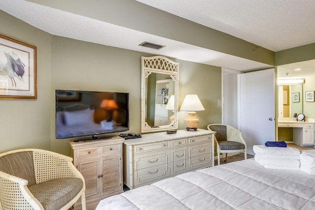 bedroom featuring a textured ceiling and connected bathroom