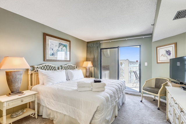 bedroom with a textured ceiling, access to exterior, and light colored carpet