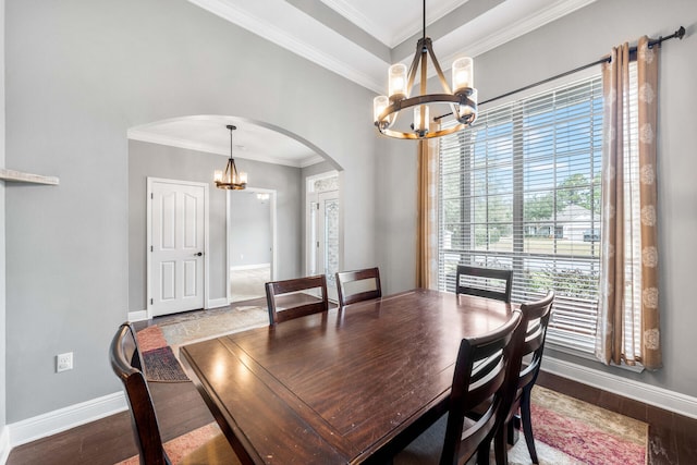 dining room with hardwood / wood-style flooring, ornamental molding, and an inviting chandelier