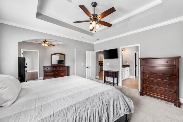 carpeted bedroom featuring crown molding, ensuite bath, and ceiling fan