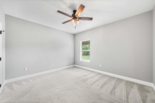 empty room featuring light colored carpet and ceiling fan