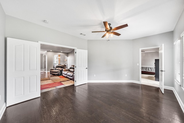 empty room featuring dark wood-type flooring and ceiling fan