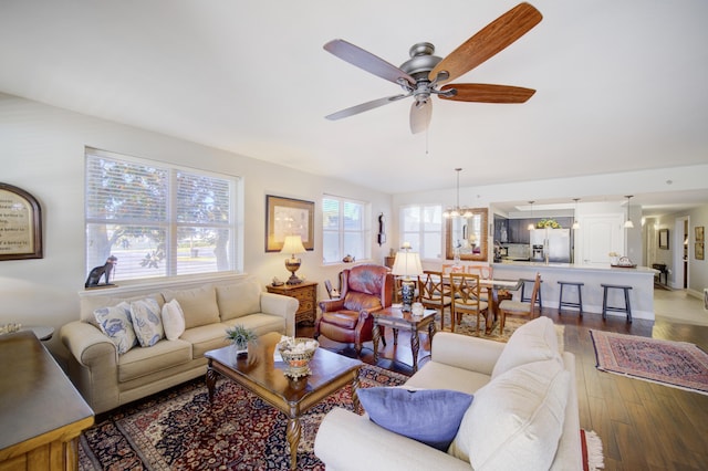 living room featuring hardwood / wood-style floors and ceiling fan with notable chandelier