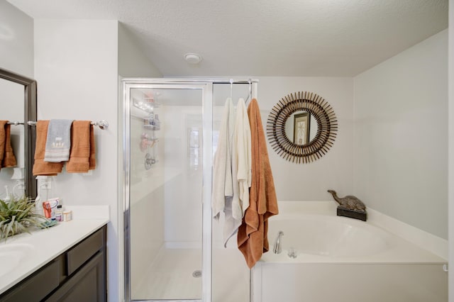 bathroom with vanity, a textured ceiling, and separate shower and tub