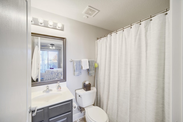 bathroom featuring vanity, a textured ceiling, toilet, and ceiling fan