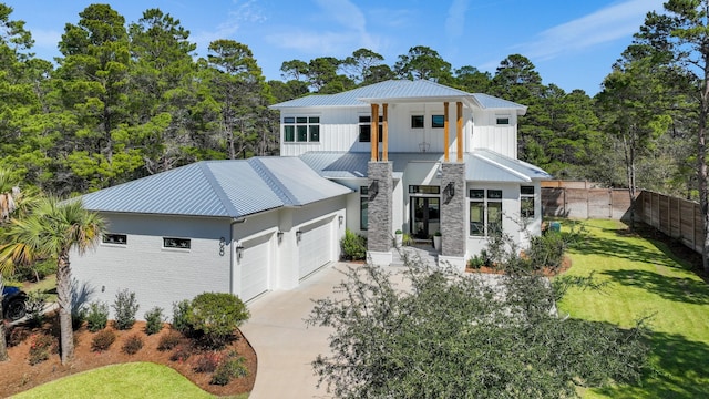 88 Beth Ln, Santa Rosa Beach, FL 32459 - view of front of house with fence, concrete driveway, a front lawn, a garage, and metal roof