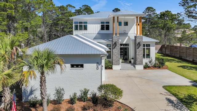 88 Beth Ln, Santa Rosa Beach, FL 32459 - view of front of house featuring brick siding, metal roof, a front yard, and fence