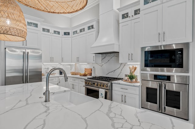 88 Beth Ln, Santa Rosa Beach, FL 32459 - kitchen featuring premium range hood, a sink, tasteful backsplash, white cabinets, and built in appliances