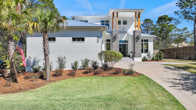 88 Beth Ln, Santa Rosa Beach, FL 32459 - view of front of home with metal roof, brick siding, a front yard, and fence