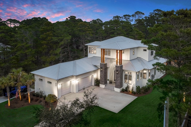 88 Beth Ln, Santa Rosa Beach, FL 32459 - view of front of property with stucco siding, driveway, a yard, an attached garage, and metal roof