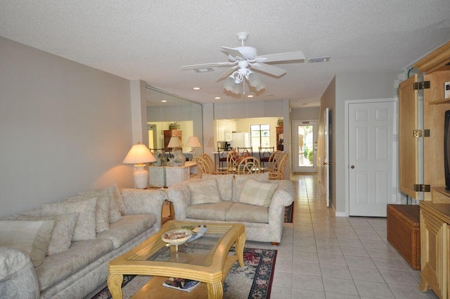 tiled living room featuring a textured ceiling and ceiling fan