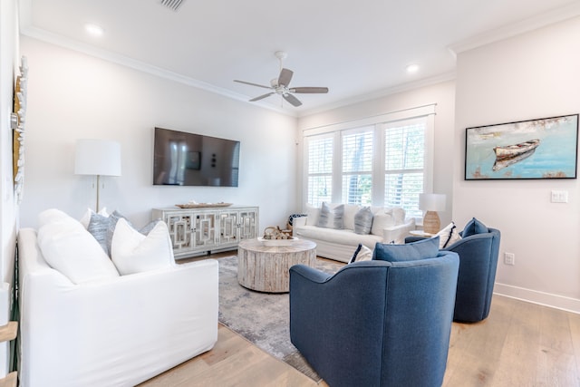 living room with ceiling fan, ornamental molding, and light hardwood / wood-style flooring