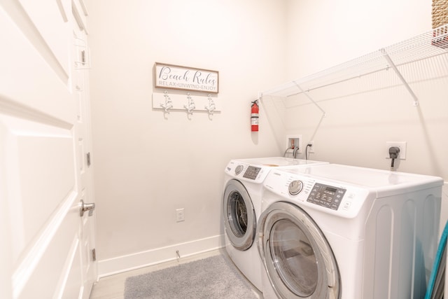 clothes washing area with washing machine and dryer