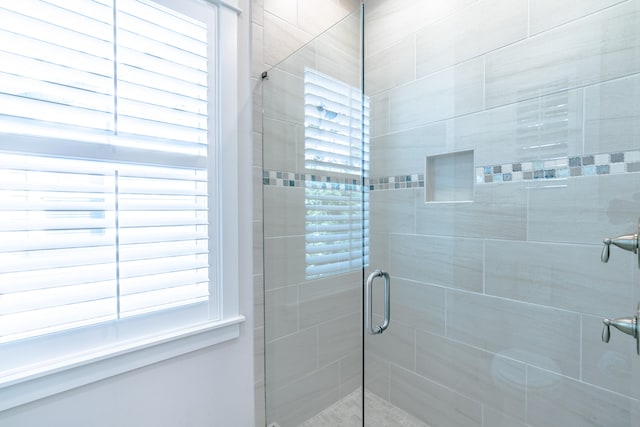 bathroom featuring a shower with shower door