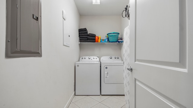 clothes washing area featuring electric panel, washing machine and dryer, and light tile patterned floors