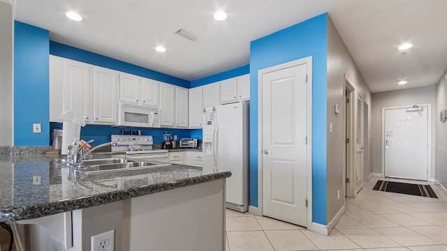 kitchen with kitchen peninsula, white cabinetry, and white appliances