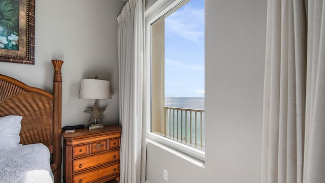 bedroom with a water view and multiple windows