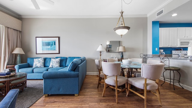 living room with ceiling fan, ornamental molding, and dark hardwood / wood-style floors