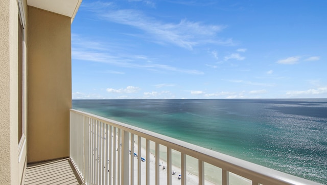 balcony with a water view and a view of the beach