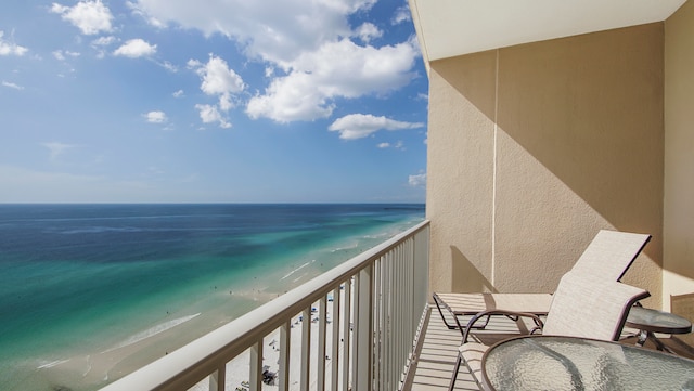 balcony featuring a water view and a beach view