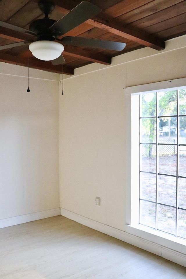 unfurnished room with baseboards, a ceiling fan, wood finished floors, and beam ceiling