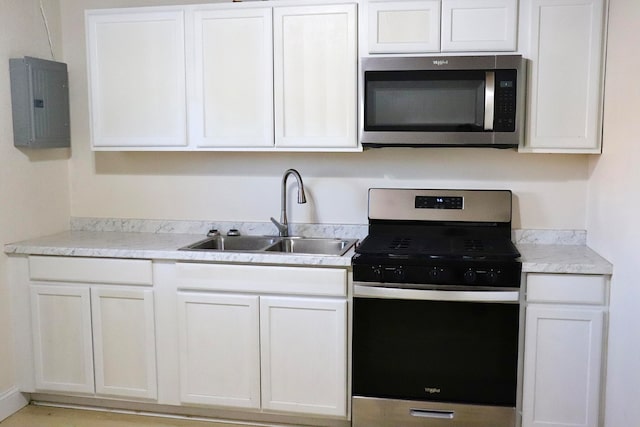 kitchen with appliances with stainless steel finishes, electric panel, and white cabinets