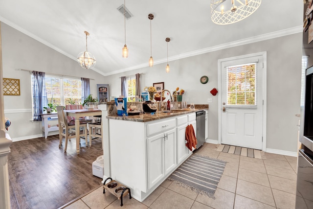 kitchen with sink, dark stone counters, stainless steel dishwasher, decorative light fixtures, and white cabinets