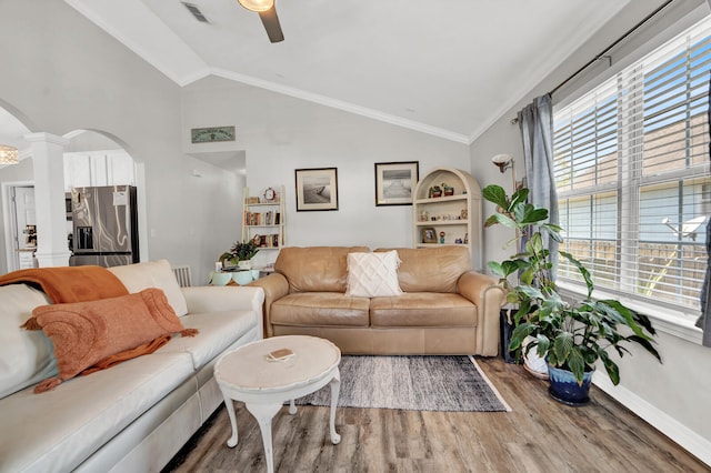 living room with lofted ceiling, ornamental molding, wood-type flooring, and decorative columns