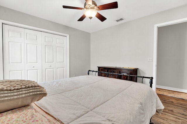 bedroom with a closet, hardwood / wood-style floors, and ceiling fan