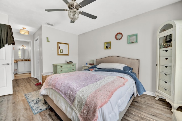 bedroom featuring ensuite bathroom, hardwood / wood-style flooring, and ceiling fan